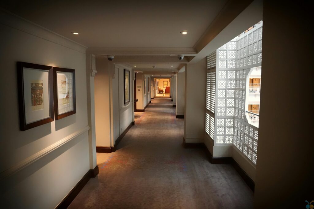 A modern hotel hallway featuring elegant design and soft lighting creating a warm ambiance.
