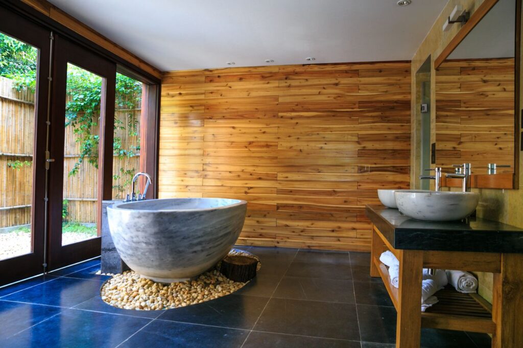 Elegant bathroom showcasing a modern marble tub and wooden interior for a serene escape.
